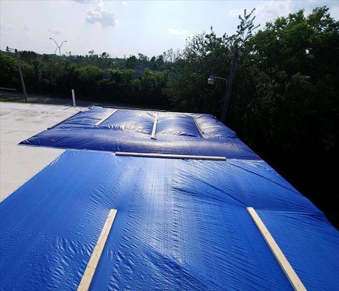 A restored roof after storm damage, covered in a tarp.