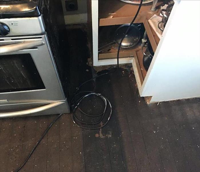A kitchen floor ruined from water damage.